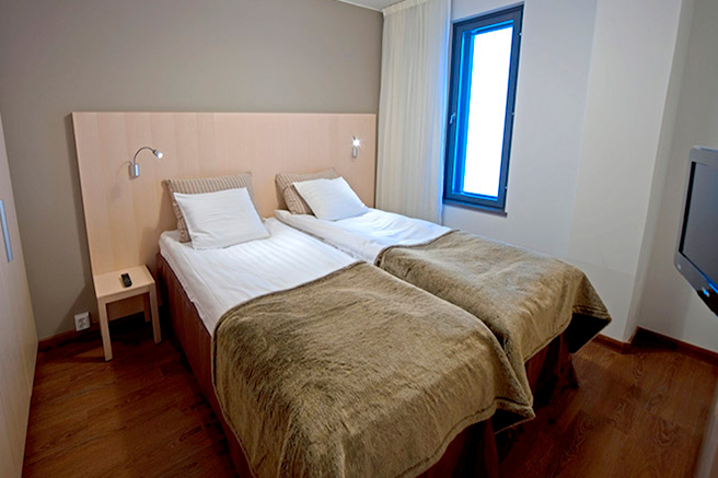 Hotel Levi Panoraman Sky Suite Deluxessa on erillinen makuuhuone lasikattoisen oleskelutilan ja olohuoneen lisäksi.